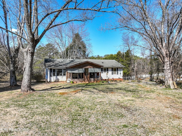 rear view of property featuring a lawn