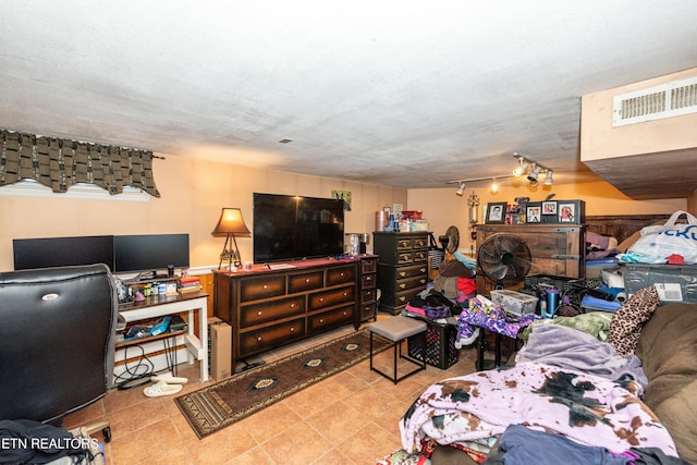 bedroom with tile patterned floors, visible vents, a textured ceiling, and track lighting