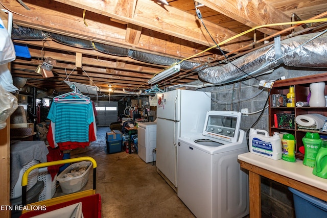 unfinished basement featuring freestanding refrigerator and washing machine and clothes dryer