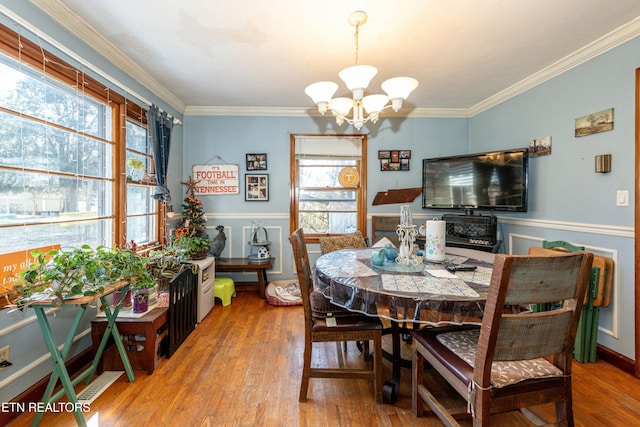 dining room featuring a notable chandelier, wood finished floors, and crown molding