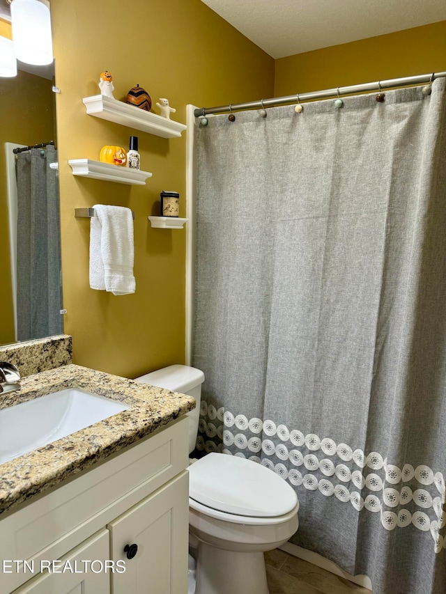 bathroom with vanity, a textured ceiling, and toilet