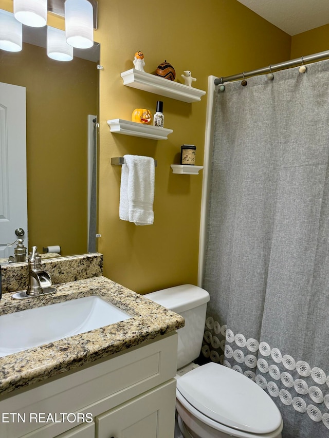 bathroom with vanity, toilet, and a shower with curtain