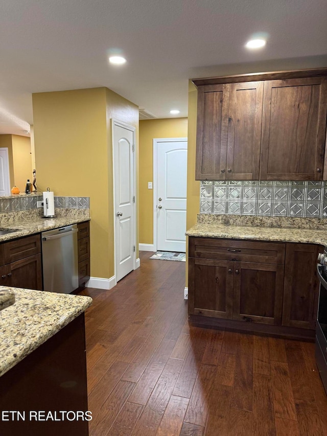 kitchen featuring decorative backsplash, dark wood-type flooring, dark brown cabinets, appliances with stainless steel finishes, and light stone counters