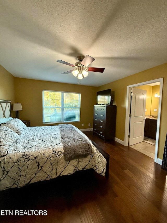 bedroom featuring a textured ceiling, hardwood / wood-style flooring, connected bathroom, and ceiling fan