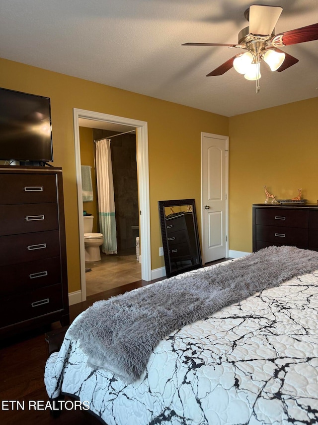 bedroom featuring dark wood-type flooring, connected bathroom, and ceiling fan