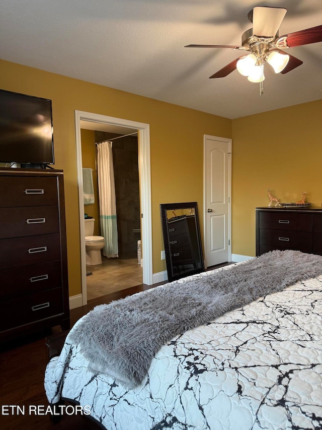 bedroom featuring dark hardwood / wood-style flooring, ensuite bath, and ceiling fan