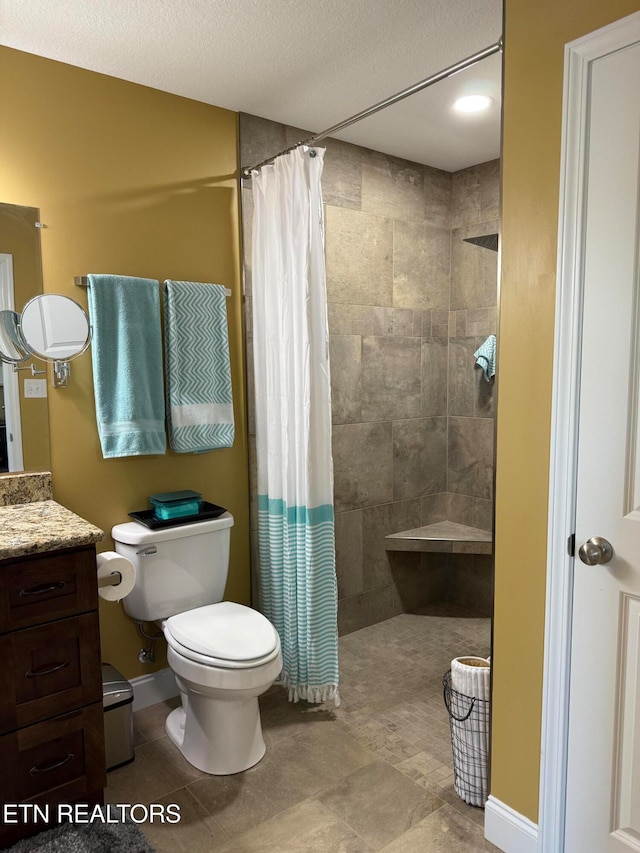 bathroom with vanity, a shower with shower curtain, a textured ceiling, and toilet