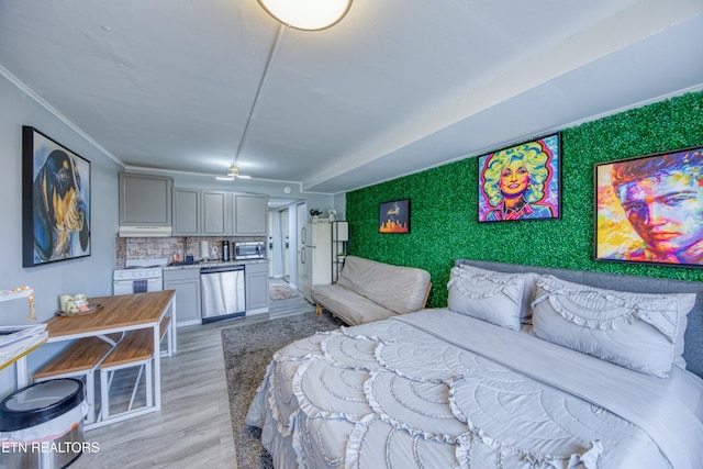 bedroom featuring crown molding, white fridge, and light wood-type flooring