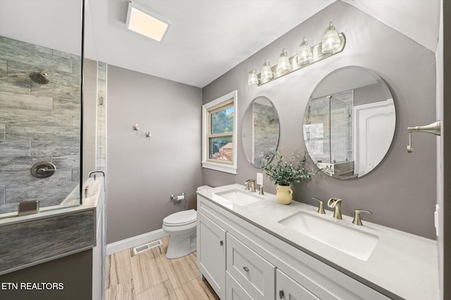 bathroom with vanity, toilet, hardwood / wood-style flooring, and a shower with shower door