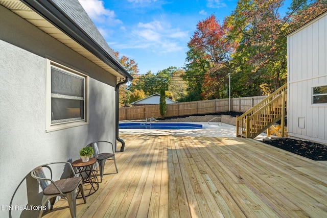 wooden terrace with a fenced in pool