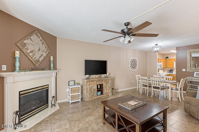 tiled living room with a premium fireplace, a textured ceiling, and ceiling fan