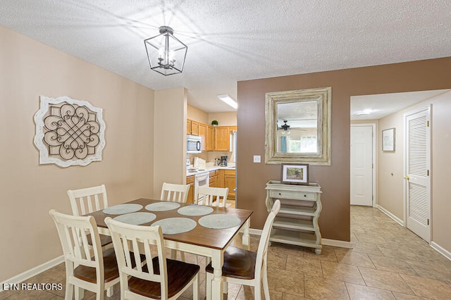 dining area featuring a textured ceiling and a chandelier