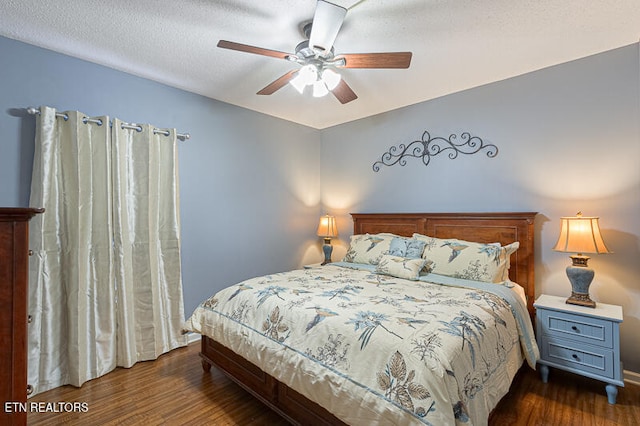 bedroom with a textured ceiling, dark wood-type flooring, and ceiling fan