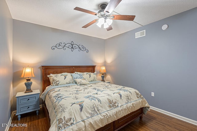 bedroom featuring ceiling fan, a textured ceiling, and dark hardwood / wood-style flooring