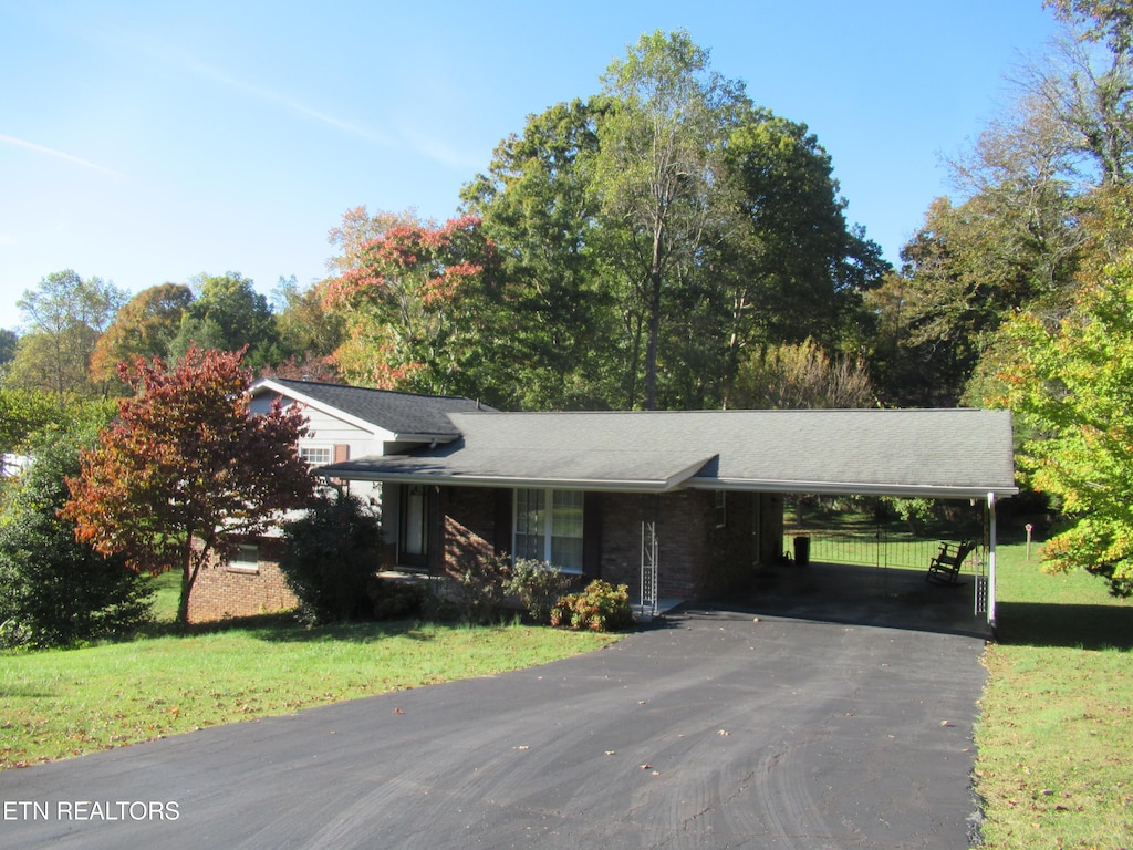 view of front of property with a front lawn and a carport