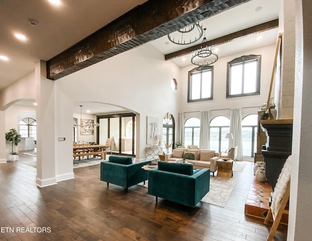 8719 Inlet Dr, Knoxville, TN 37922 - living area with arched walkways, beamed ceiling, dark wood-style floors, a high ceiling, and healthy amount of natural light