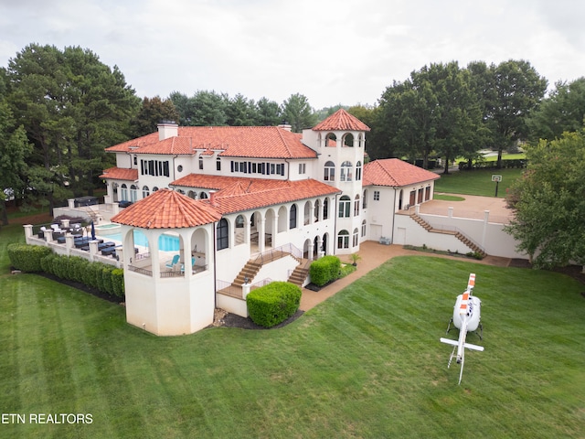 rear view of house with a patio and a lawn