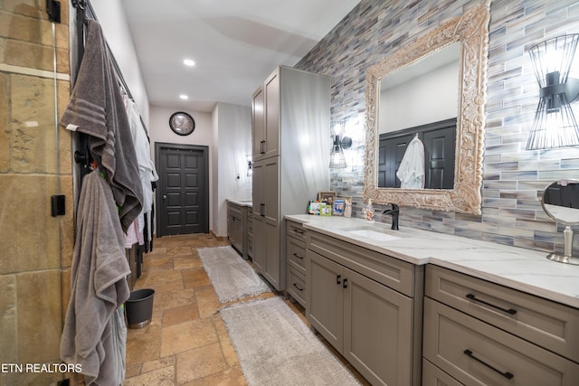 8719 Inlet Dr, Knoxville, TN 37922 - bathroom featuring stone tile floors, vanity, backsplash, and recessed lighting