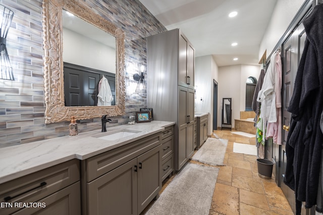 bathroom featuring vanity and decorative backsplash