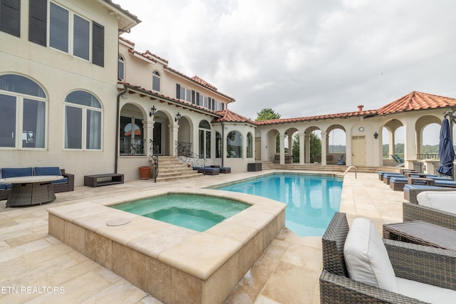 view of pool featuring an in ground hot tub and a patio