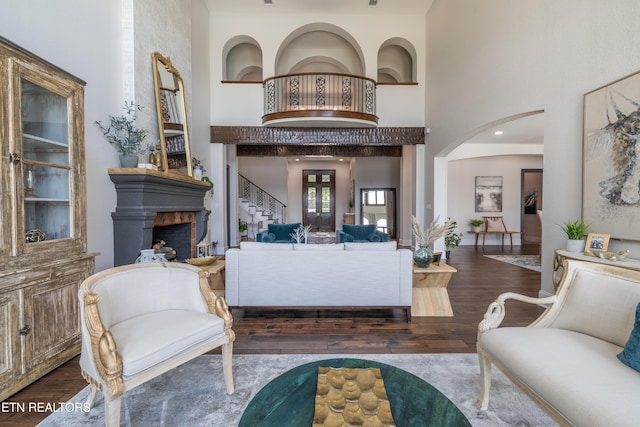 8719 Inlet Dr, Knoxville, TN 37922 - living area featuring a towering ceiling, a fireplace, stairway, wood finished floors, and arched walkways