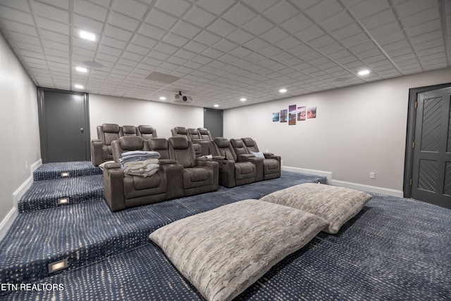 carpeted cinema with a drop ceiling