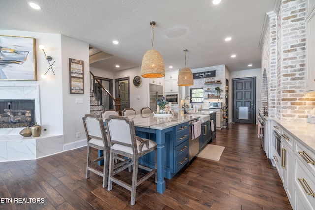 8719 Inlet Dr, Knoxville, TN 37922 - kitchen with a breakfast bar, white cabinets, appliances with stainless steel finishes, blue cabinets, and dark wood-style floors