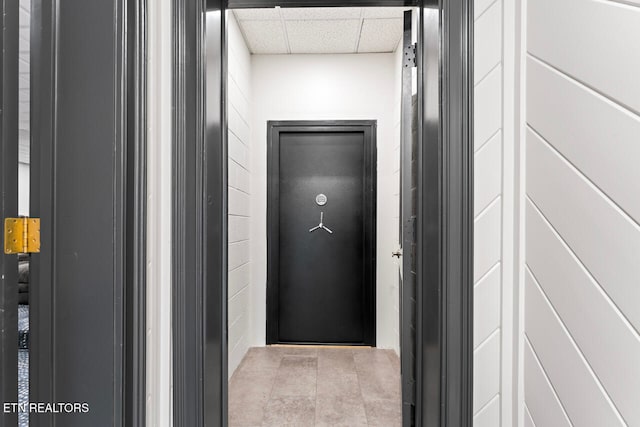 corridor featuring a drop ceiling and elevator