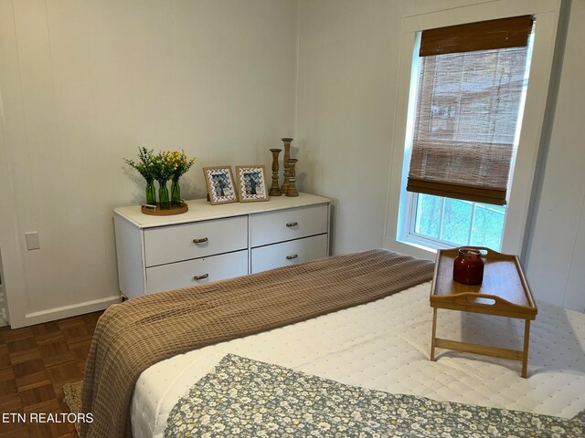 bedroom with dark parquet flooring