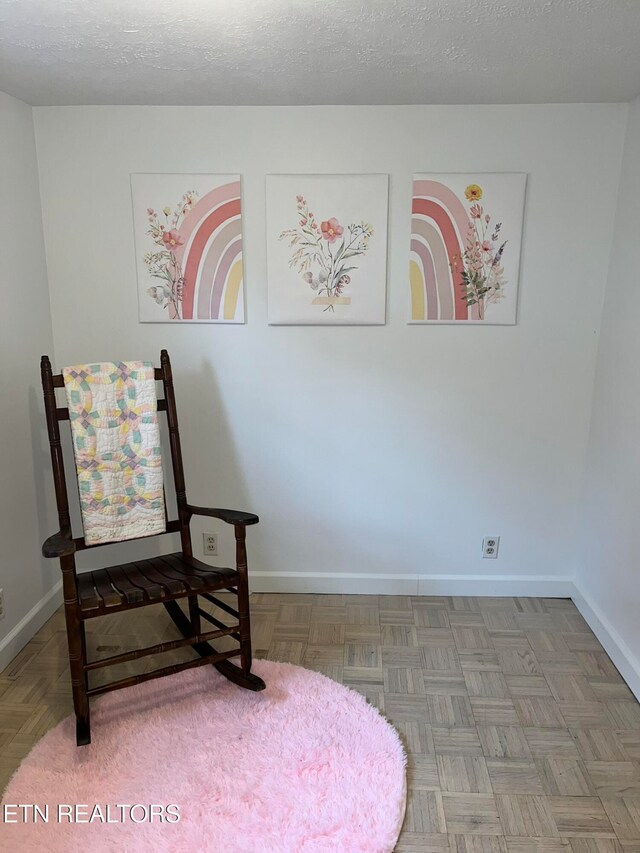 sitting room featuring a textured ceiling and parquet flooring