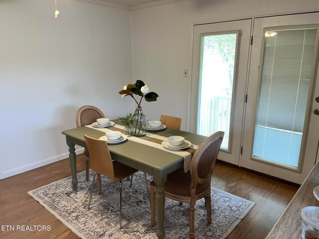 dining room featuring crown molding and dark wood-type flooring