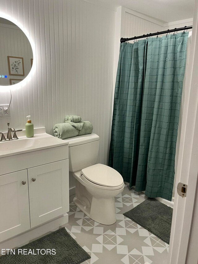 bathroom with tile patterned floors, vanity, curtained shower, and toilet