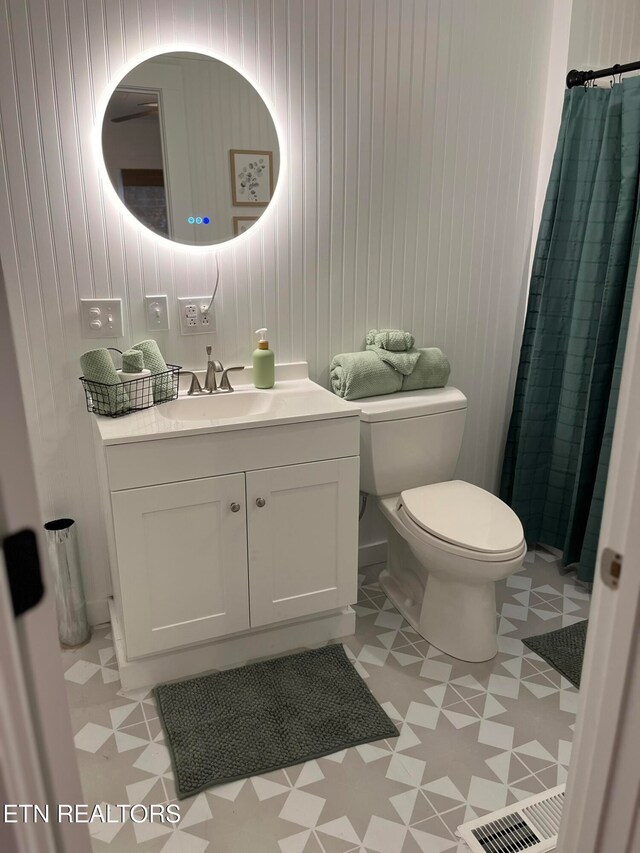 bathroom with tile patterned floors, vanity, toilet, and walk in shower