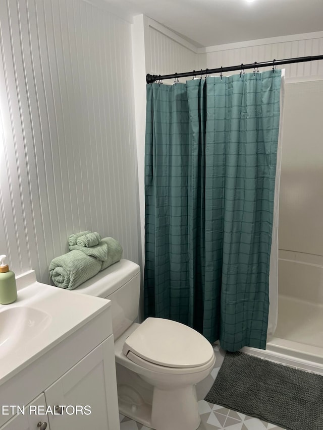 bathroom featuring vanity, wooden walls, toilet, ornamental molding, and curtained shower