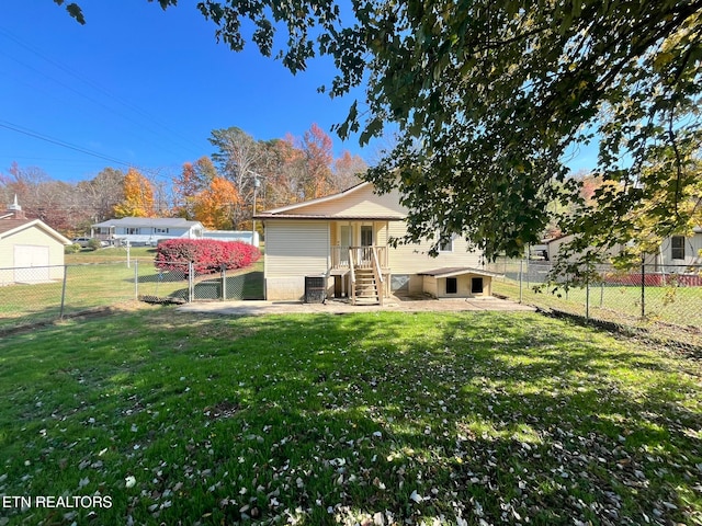 back of house with a yard and central AC