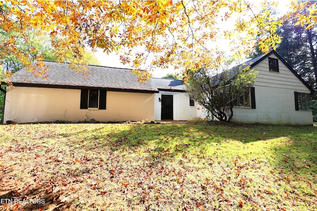 back of house with a lawn