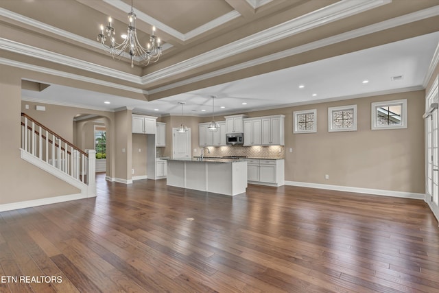 unfurnished living room with crown molding, a notable chandelier, and dark hardwood / wood-style flooring