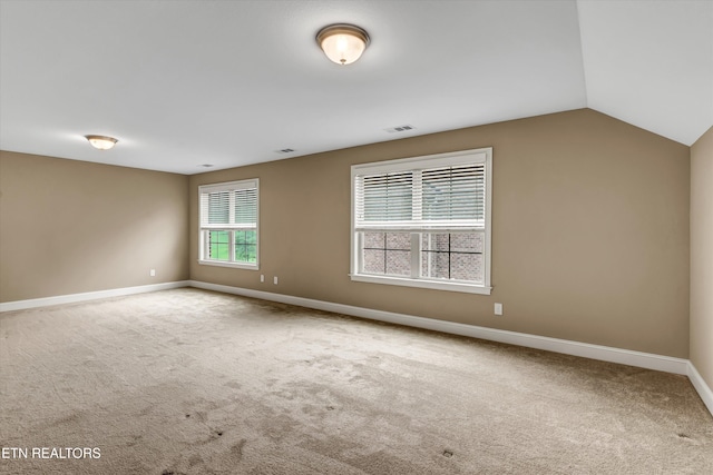 empty room featuring carpet flooring and lofted ceiling