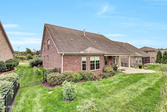 rear view of house with a yard and a patio area