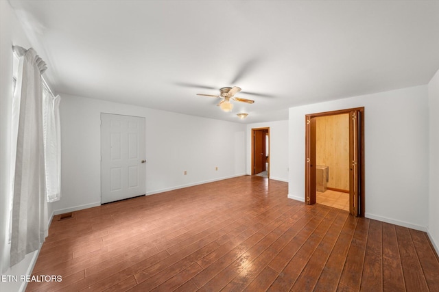 spare room with dark hardwood / wood-style flooring and ceiling fan