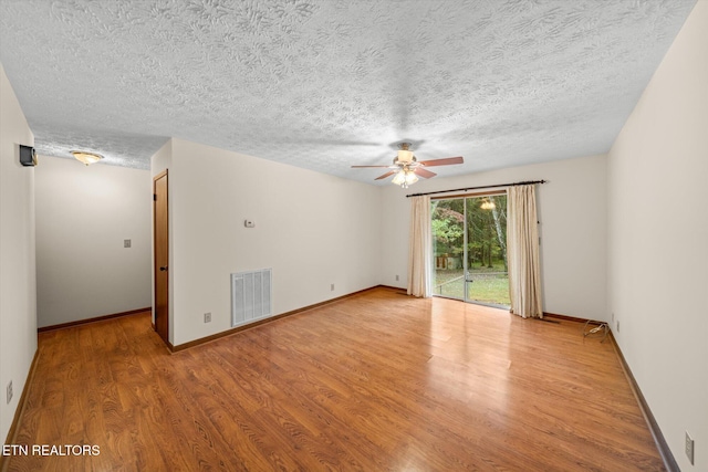 spare room featuring light wood-type flooring, a textured ceiling, and ceiling fan