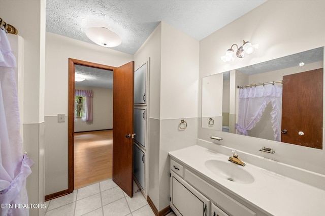 bathroom with vanity, tile patterned flooring, and a textured ceiling