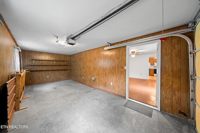 garage with wooden walls, ceiling fan, and a garage door opener