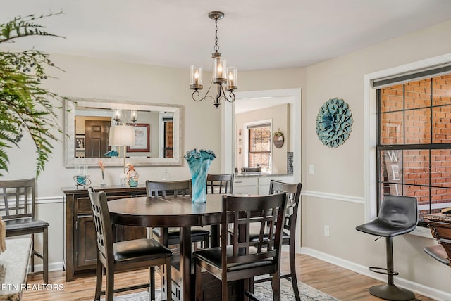 dining area featuring a notable chandelier and light wood-type flooring