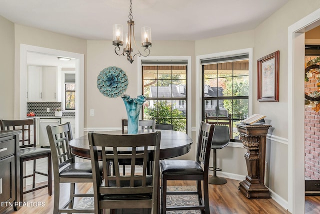 dining room with hardwood / wood-style floors and an inviting chandelier