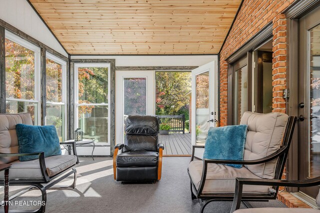 sunroom featuring lofted ceiling and wooden ceiling