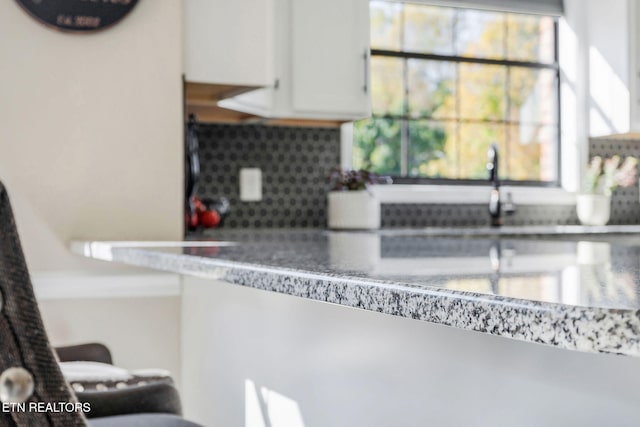 interior space featuring backsplash and white cabinets