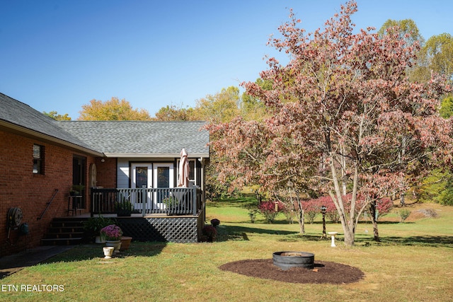 view of yard with a deck and a fire pit