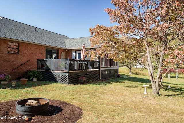 view of yard featuring a wooden deck and an outdoor fire pit