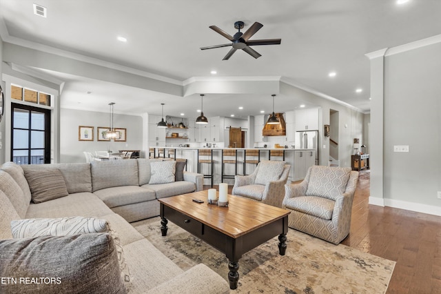 living room featuring crown molding, ceiling fan, and hardwood / wood-style flooring